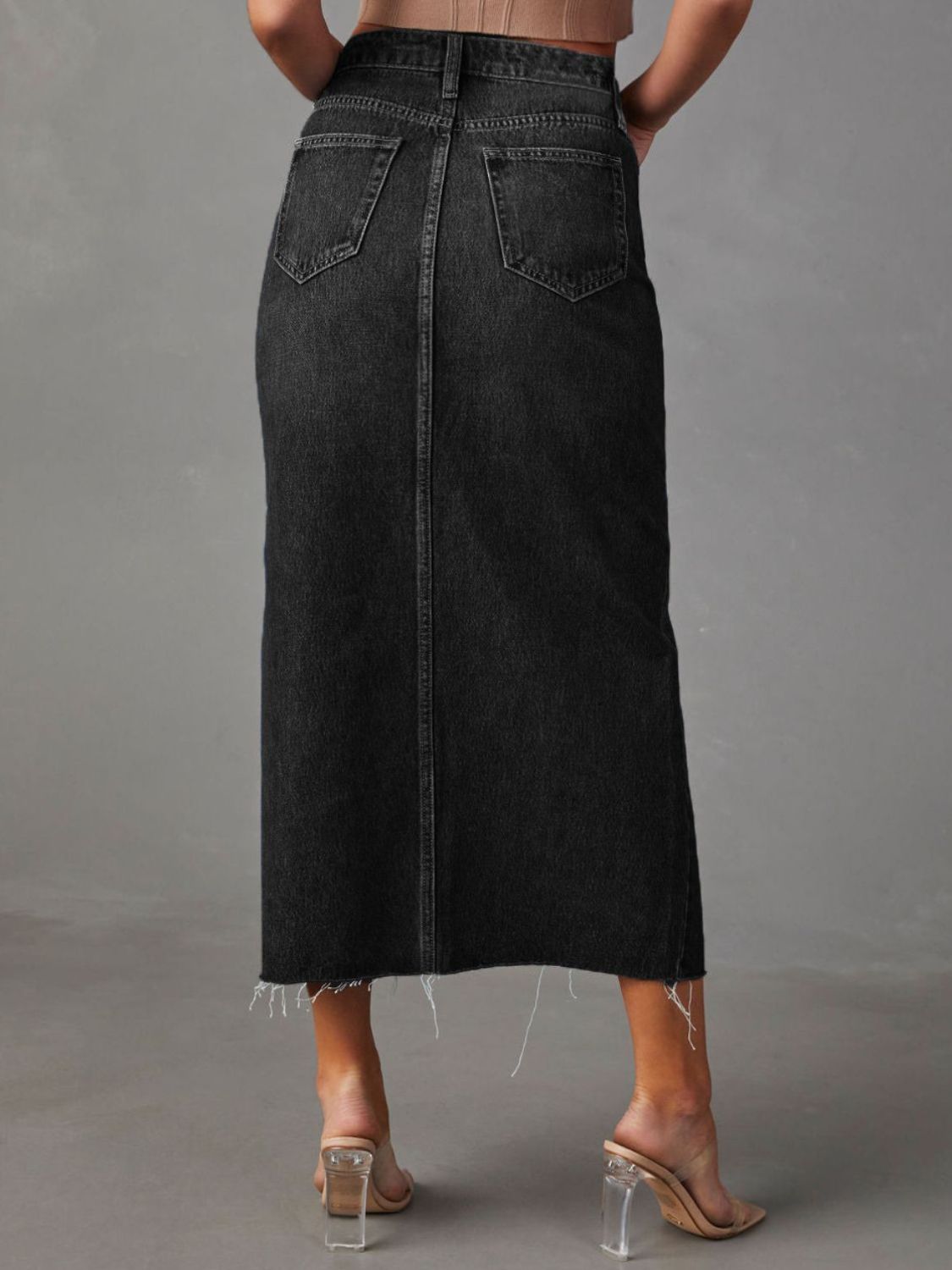 Dark wash denim midi skirt with raw hem and back pockets.