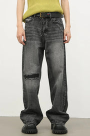 Baggy fit dark washed denim jeans with knee rips and a distressed look.