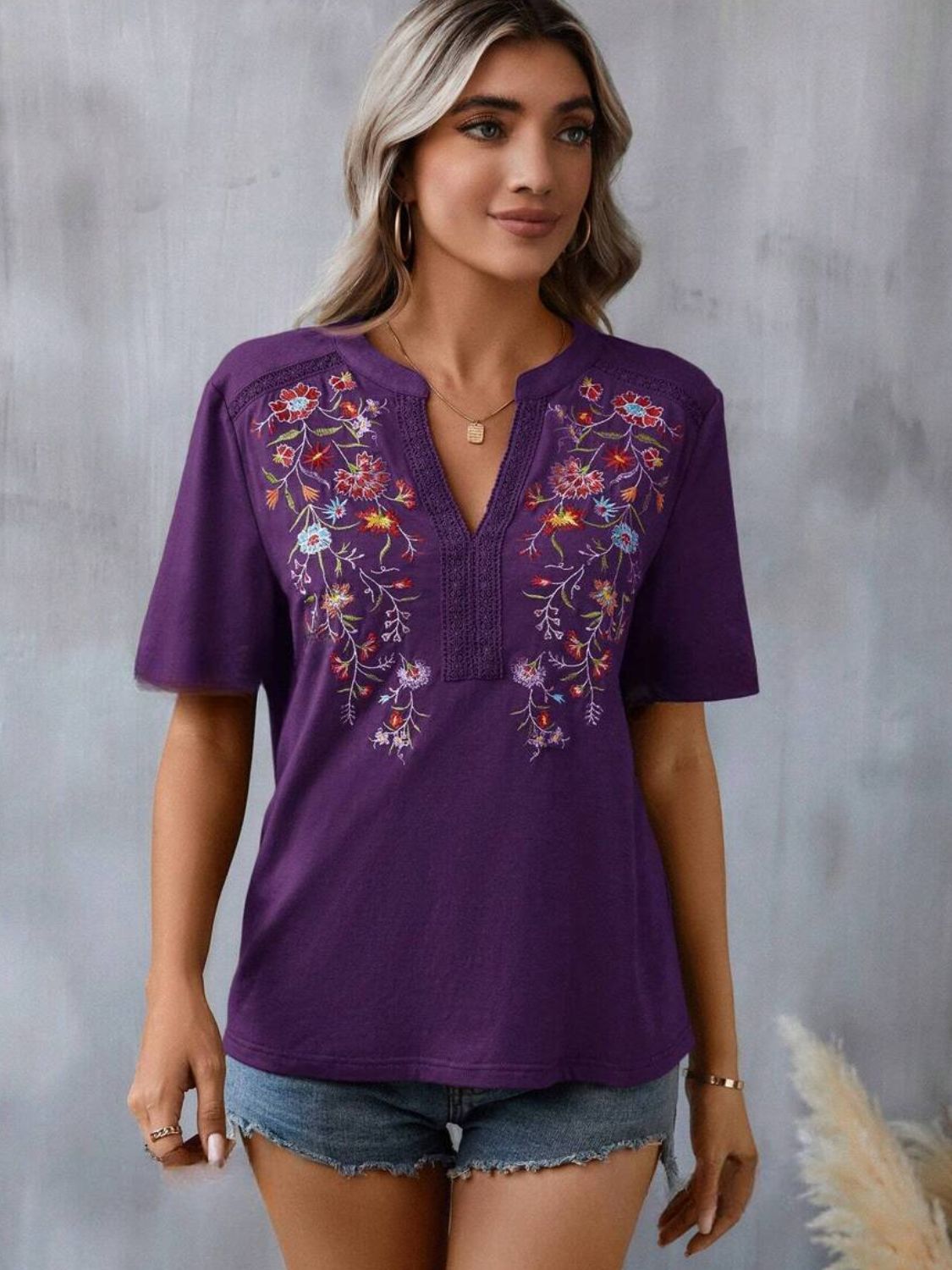 Violet v-neck tee with floral embroidery and crochet trim details.