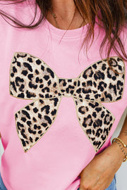 Pink cotton t-shirt with crew neck and leopard print bow graphic detail.