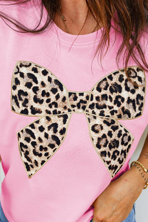Pink cotton t-shirt with crew neck and leopard print bow graphic detail.