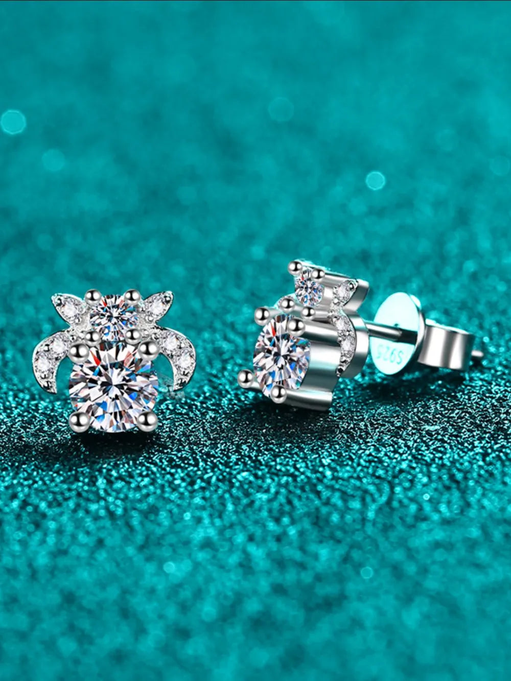 Silver moissanite floral cluster stud earrings with sparkling round-cut center stones and smaller accent gems.