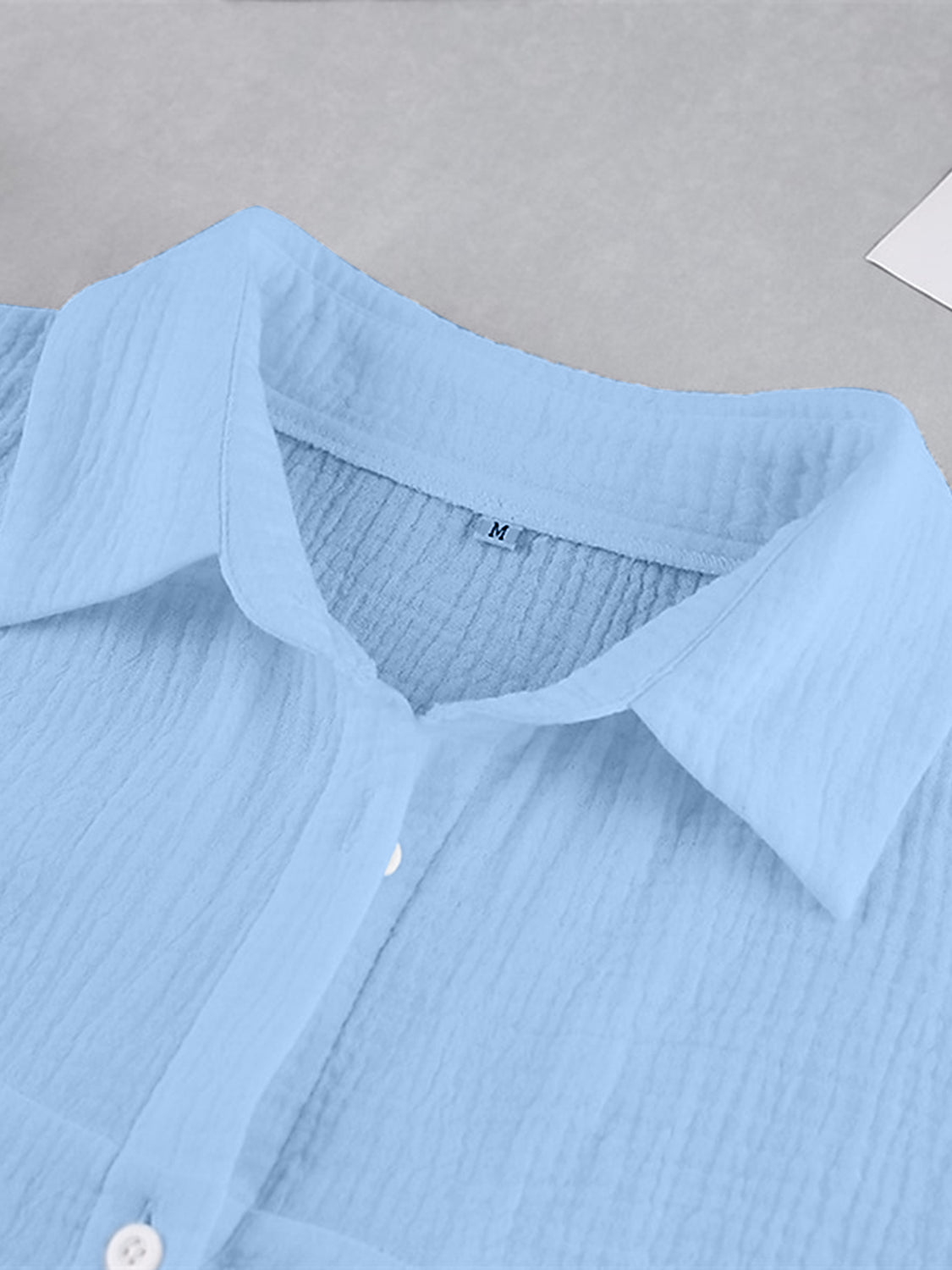 Light blue textured cotton button-up shirt with a collared neckline.