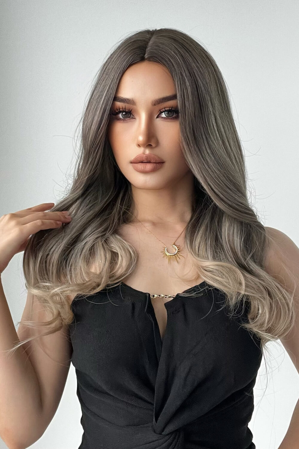 Ombre wave synthetic wig in ash brown to blonde, styled with loose curls.