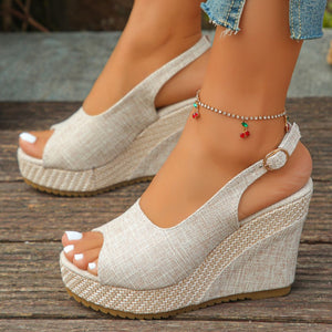 Beige woven espadrille wedge sandals with peep toe and slingback strap.