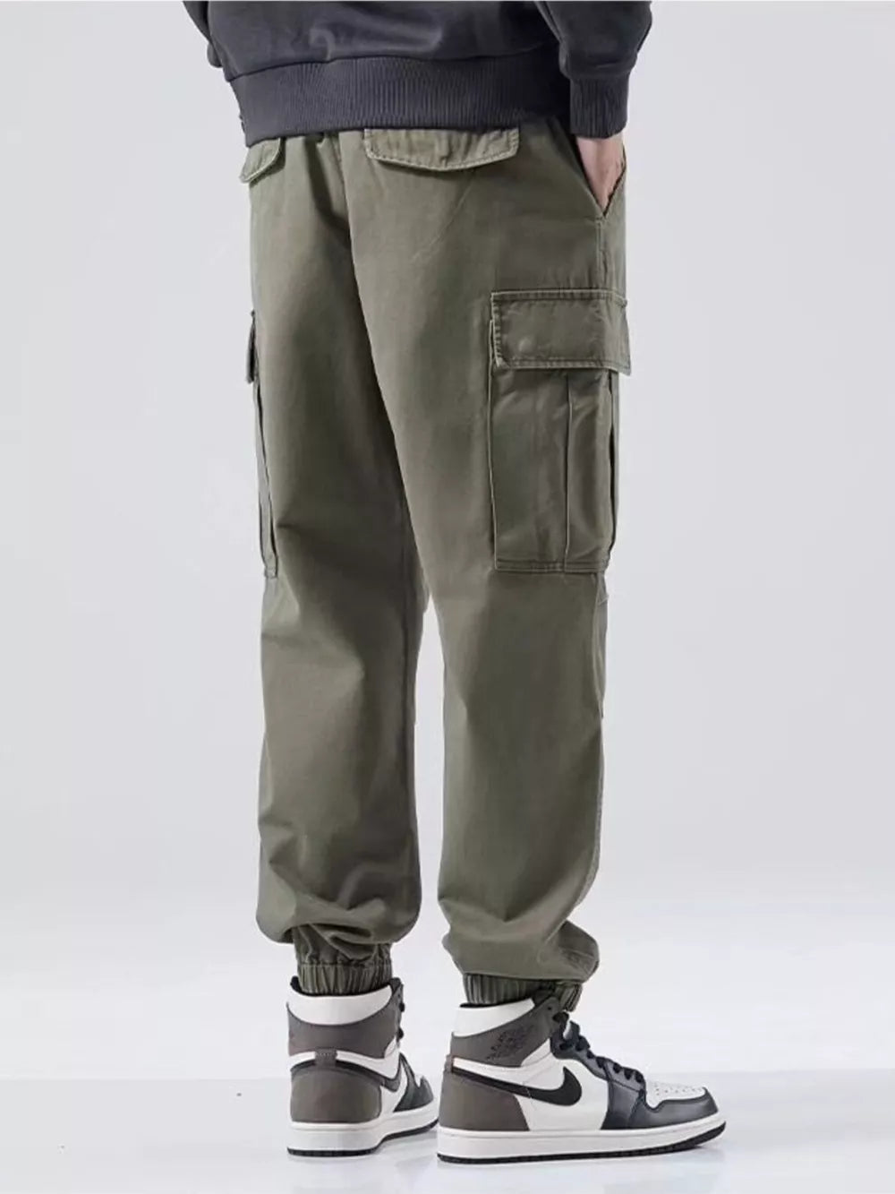 Plus-size relaxed fit cargo sweatpants in Army Green with multiple pockets and cuffed ankles.