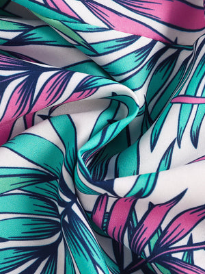 Asymmetrical top and floral shorts set fabric detail with pink, green, and navy blue leaves on white cotton.