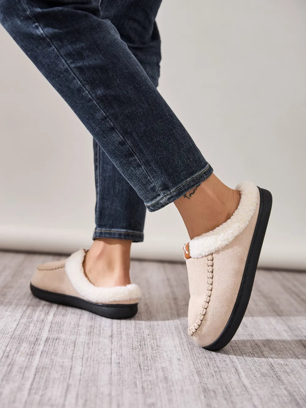 Suede shearling-lined moccasin slides in caramel with decorative stitching.