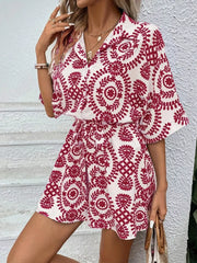 Deep Red printed tie-waist romper with button front and spread collar.