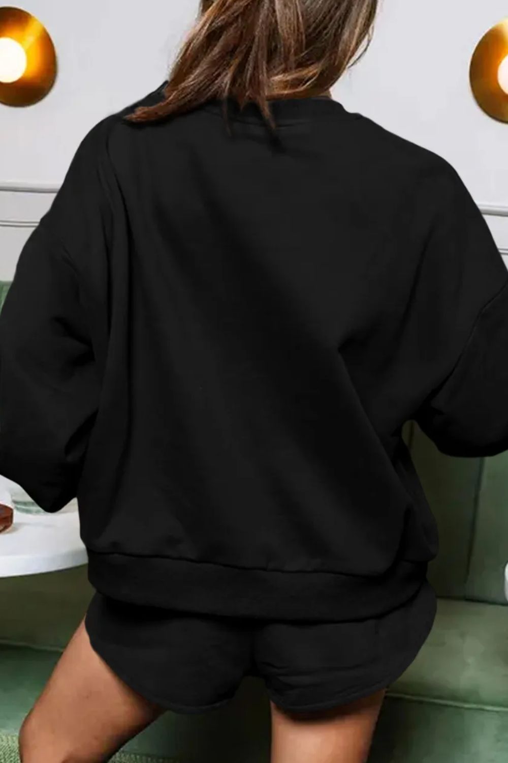 Black loungewear set with relaxed fit sweatshirt and shorts.