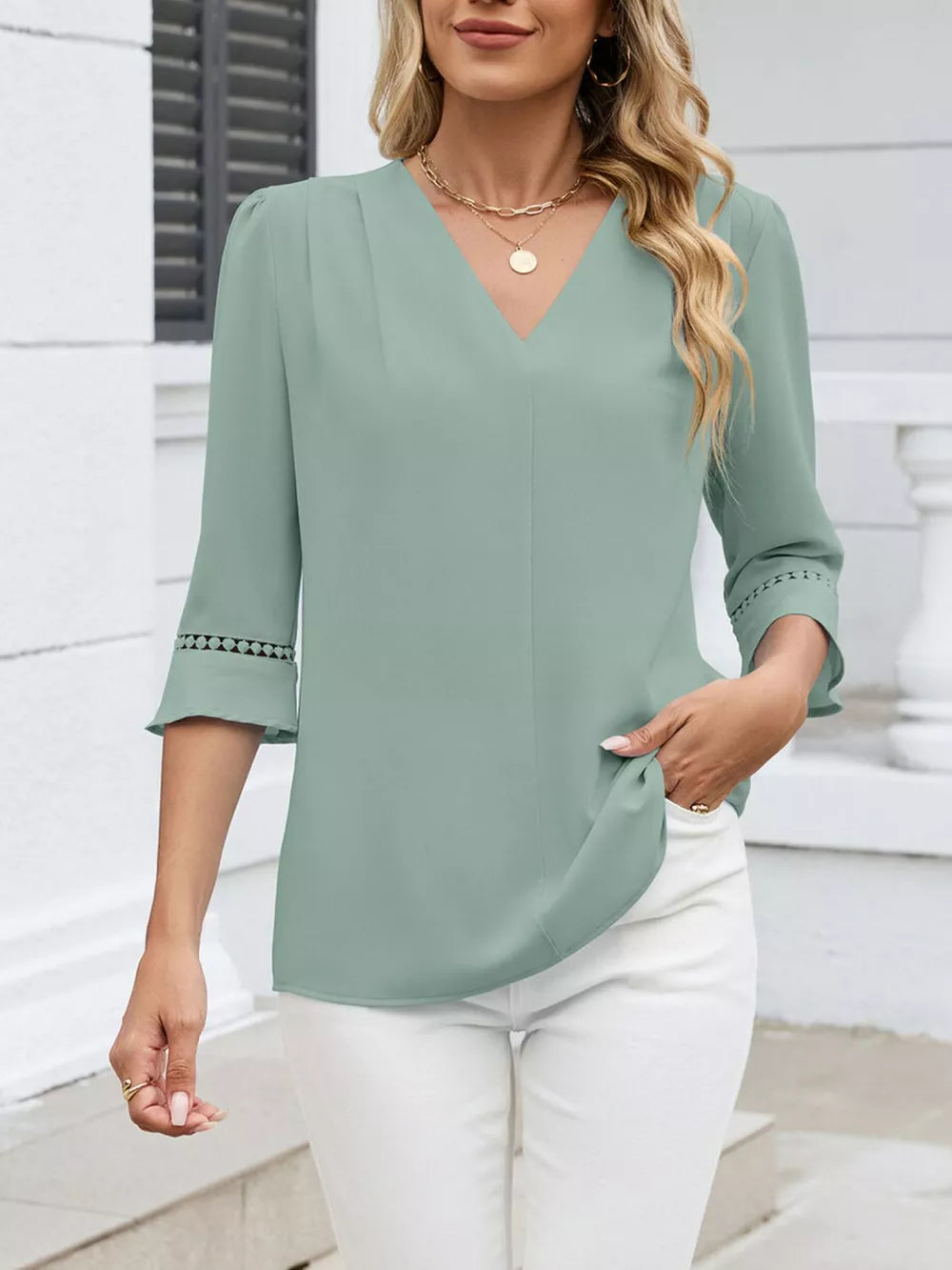 Bean green V-neck blouse with 3/4 sleeves and lace embellishments on cuffs.