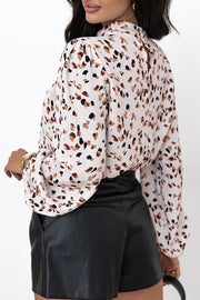 High-neck abstract print blouse in white with brown and black spots, long sleeves.