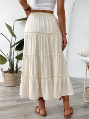 Cream tiered midi skirt with drawstring waist and ruffled seams.