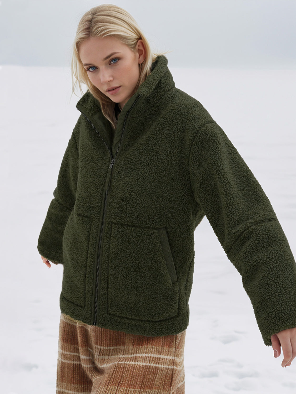 Olive green sherpa jacket with stand collar and zip front, featuring two front pockets.