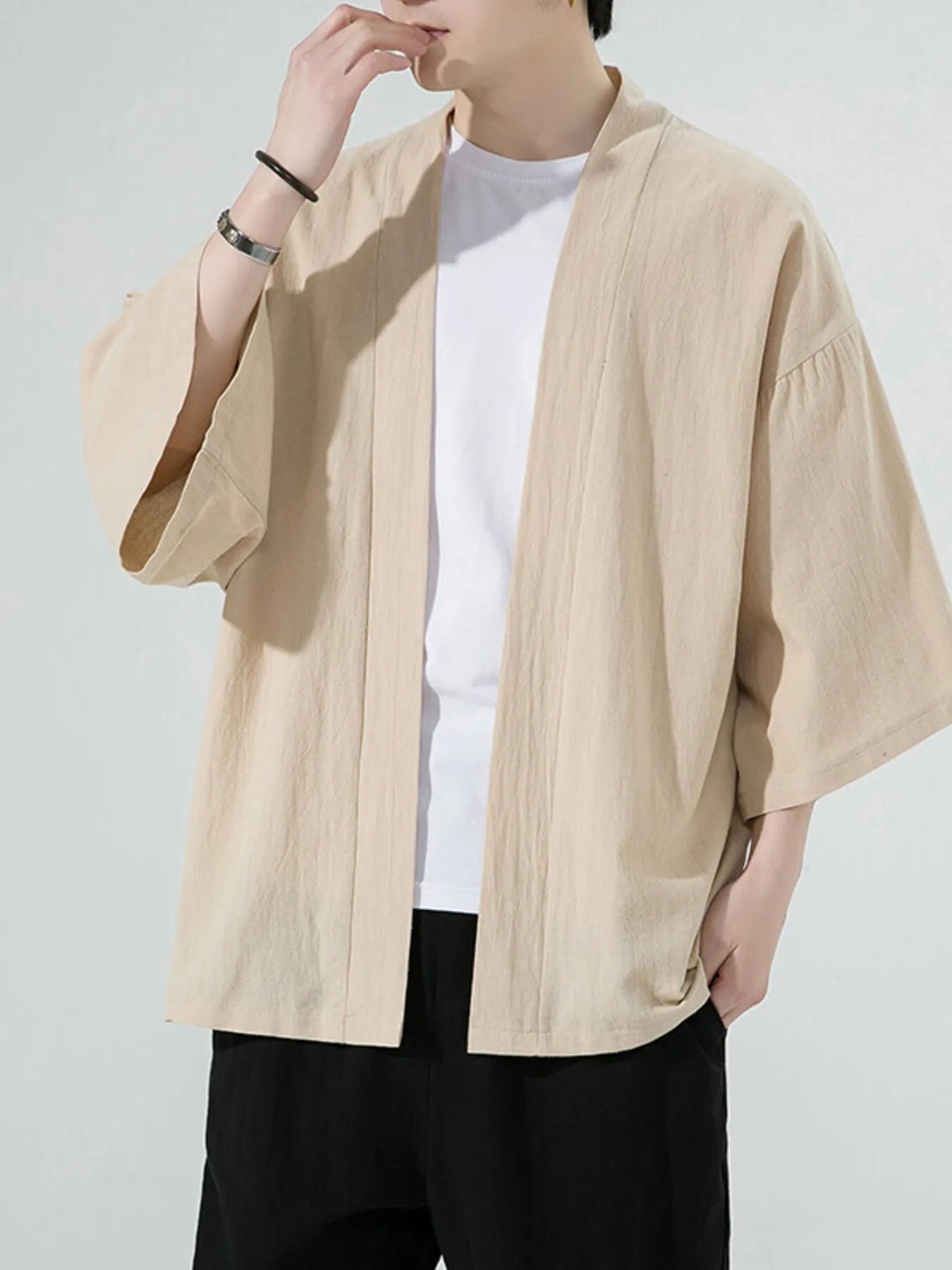 Oversized casual open front jacket in Khaki with wide sleeves and a relaxed fit, worn over a white t-shirt.