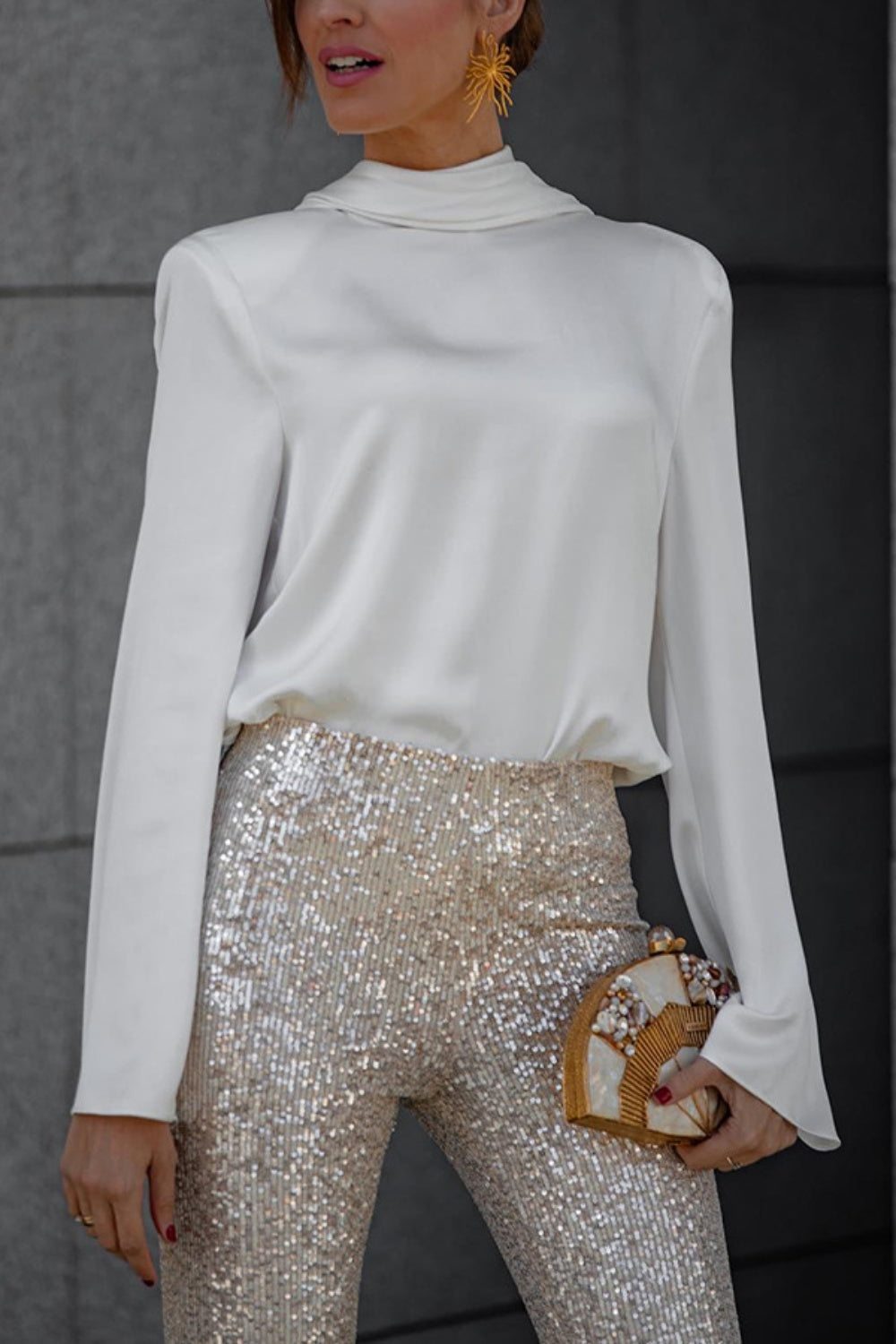White silk blouse with draped back and long sleeves worn with sequin pants