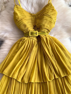 Yellow pleated midi dress with spaghetti straps and a matching belt.