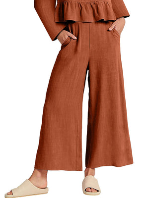 Ruffled hem two-piece set in rust orange with wide leg pants featuring pockets.
