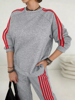 Grey two-piece lounge set with red stripe detail on sleeves and pants.