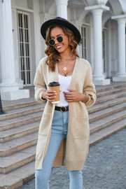 Khaki slouchy knit cardigan with pockets and ribbed trim, worn open over a white top.