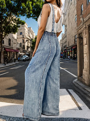 Washed denim palazzo dungarees in light blue with raw seams and wide legs.