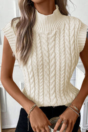 Ivory cable knit mock neck vest with chunky knit texture and sleeveless design.