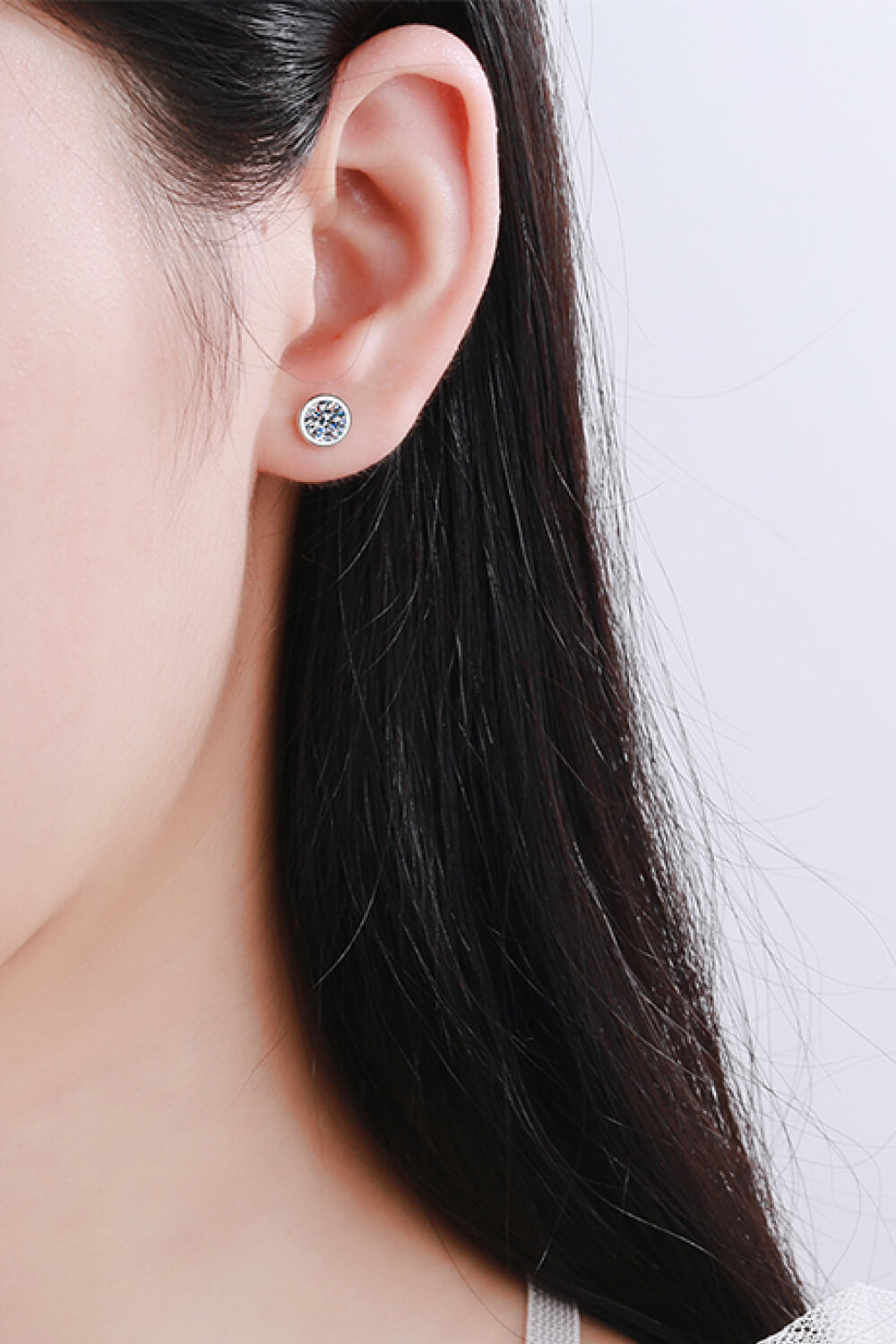 Prismatic Halo stud earrings in silver feature a round, clear gemstone.