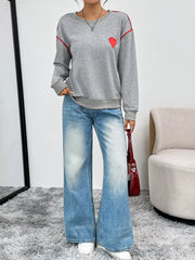 Gray sweatshirt with red heart embroidery and red stripe accents, crew neck, long sleeves.