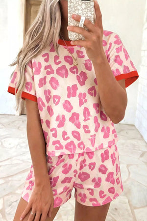 Pink leopard print polyester two-piece set with red trim on t-shirt and shorts.