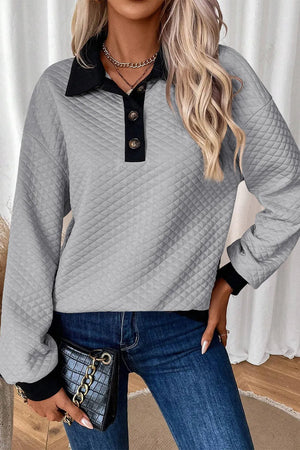 Gray diamond quilted polo sweatshirt with black collar and button placket.