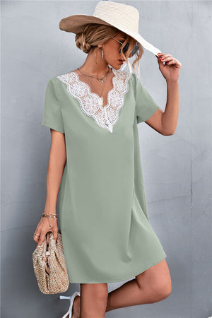 Green v-neck shift dress with white lace trim and short sleeves