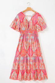 Paisley print boho dress with V-neck, short sleeves, smocked waist, and tiered skirt in burnt coral.
