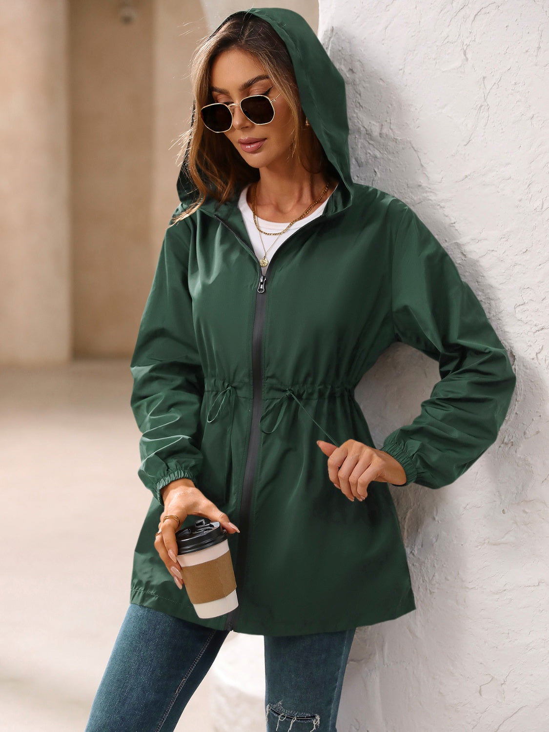 Dark green hooded jacket with cinched waistline and zip front, perfect for casual wear.