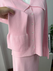 Pink ribbed knit cardigan and skirt set with button-down closure and flared cuffs.