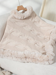 Eggshell cable knit poncho with faux fur trim and cowl neck.