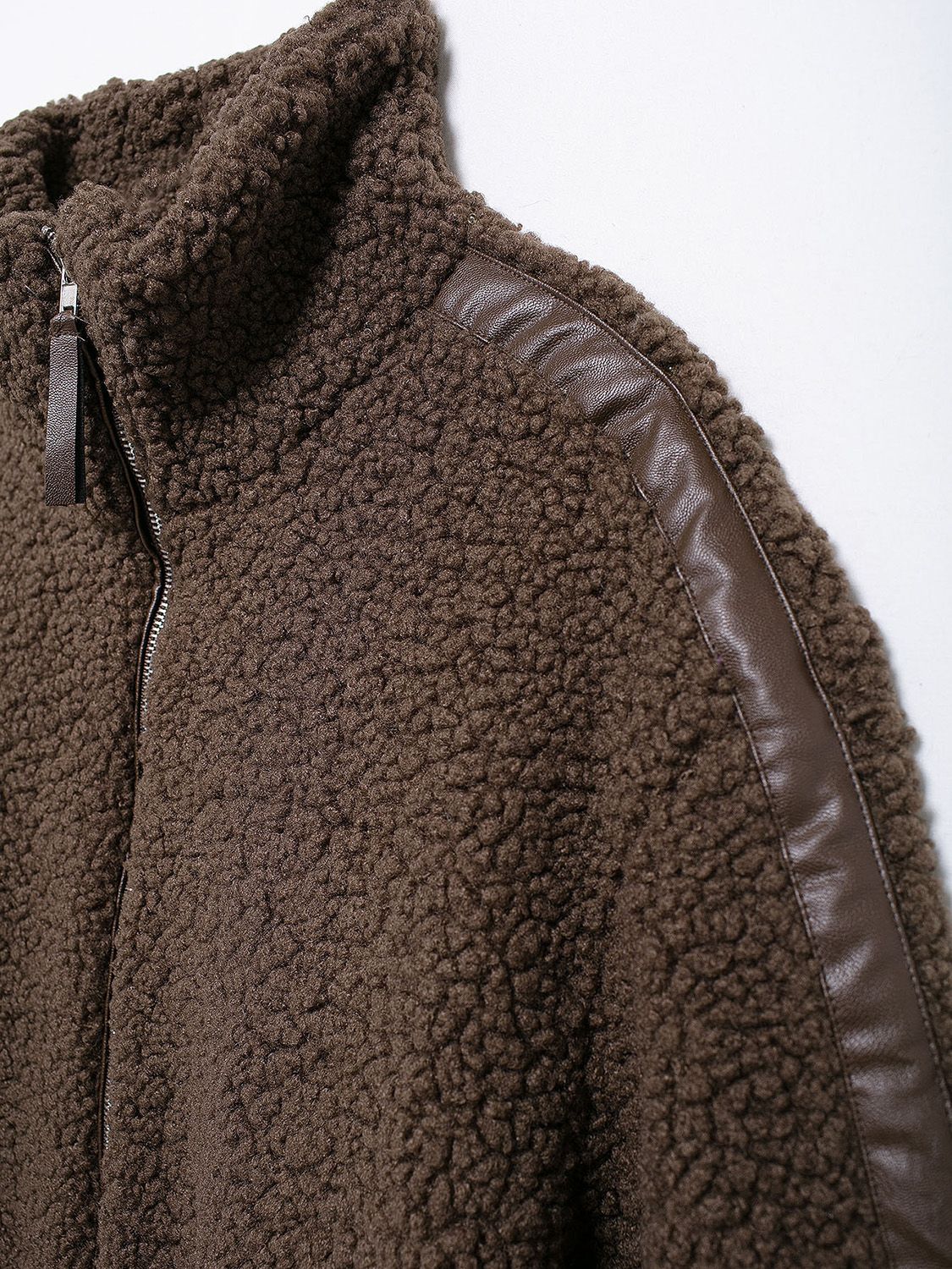 Brown teddy fleece zip-up jacket with contrast faux leather piping detail and stand-up collar.