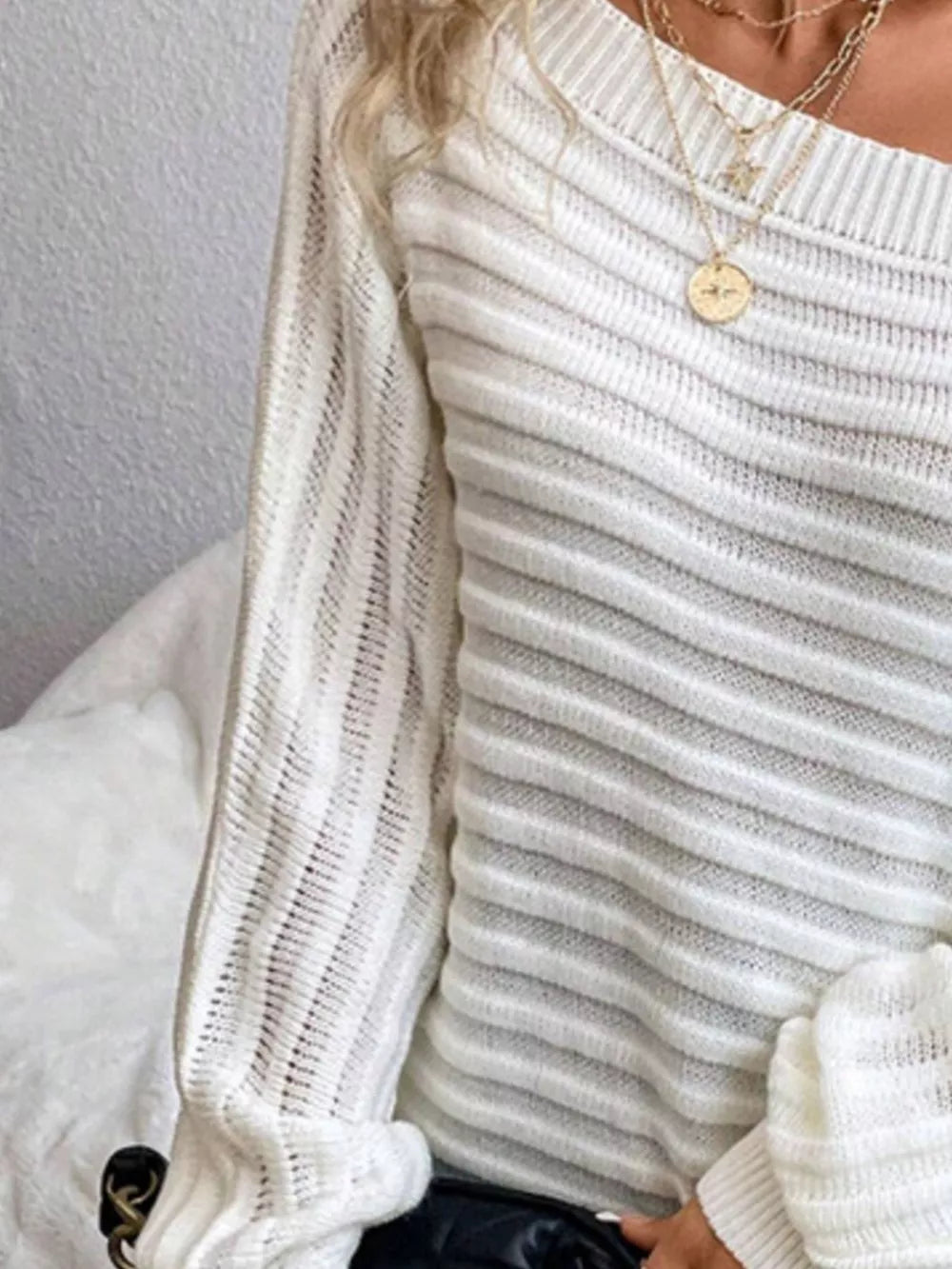 Gray/white ribbed knit sweater with one-shoulder neckline and open knit sleeves.