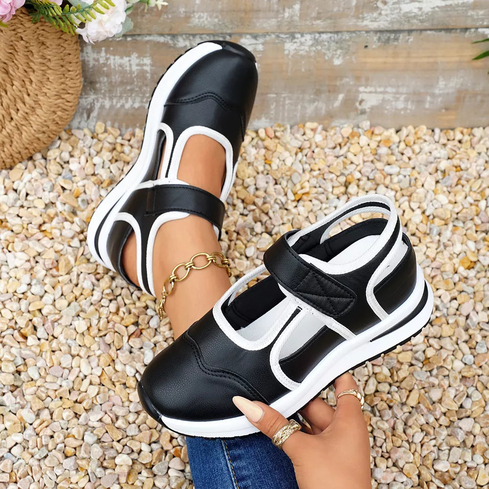 Black and white cutout Mary Jane sneakers with contrast trim and adjustable strap.