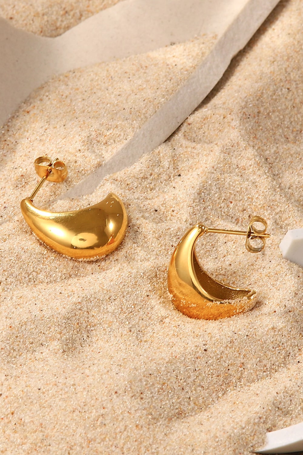 Gold sculpted crescent earrings with a polished finish.