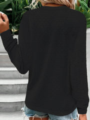 Black lace-effect henley blouse with button detail and long sleeves.