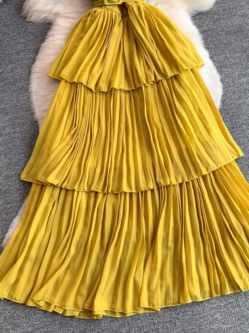 Yellow pleated midi dress with tiered skirt and belted waist
