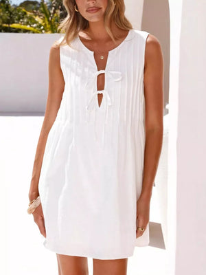 White sleeveless mini dress with tie-front neckline and subtle vertical pleats.