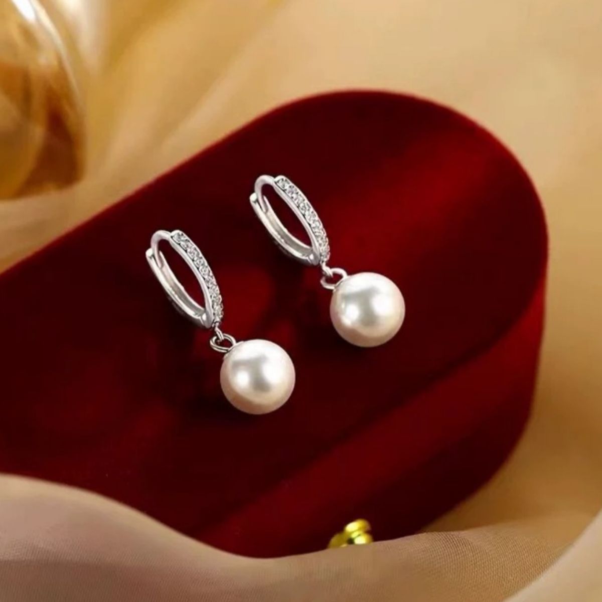 Elegant pearl drop hoop earrings with crystal accents.