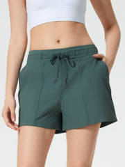 Coastal drawstring utility shorts in dark green with pockets and adjustable tie waist.