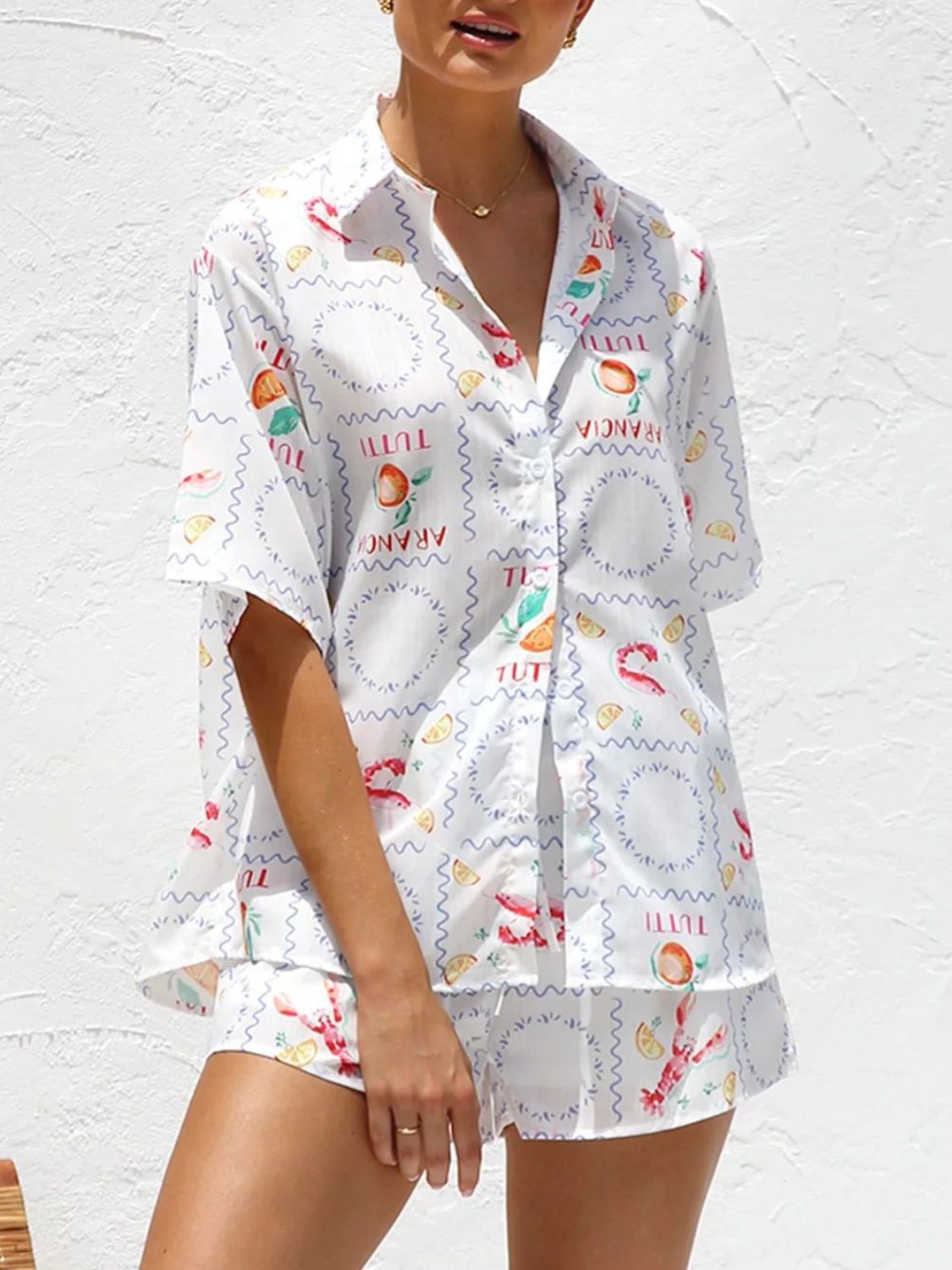 White button-up resort shirt with citrus and lobster print, short sleeves, and matching shorts.