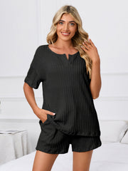 Black textured ribbed knit pajama set with short sleeves and notched neckline, featuring pockets.