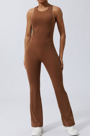 Brown cross-back flare leg unitard with ruched sides and a scoop neckline.
