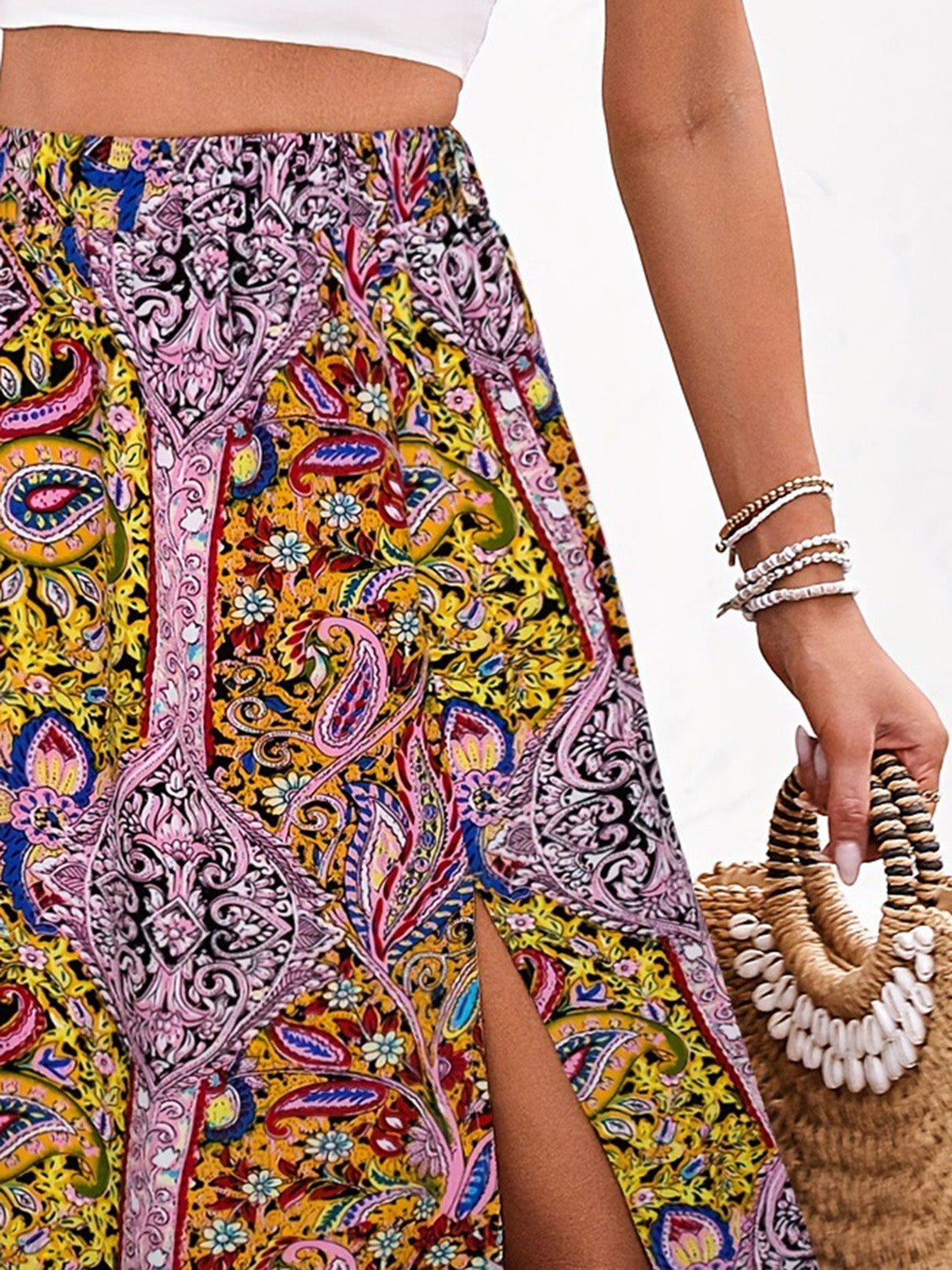 Maxi skirt with bold paisley print in yellow, pink, and blue, featuring a thigh-high slit.