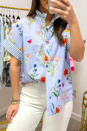 Floral patchwork maternity shirt with ruffled collar and striped cuffs.