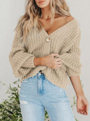 Camel knit cardigan with voluminous sleeves and button front, styled with jeans.